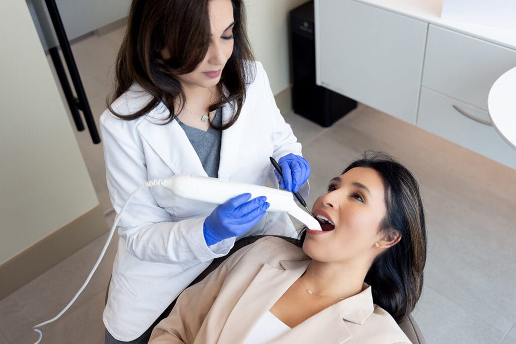 Dentist performing a digital scan of a patient's teeth for clear aligner treatment